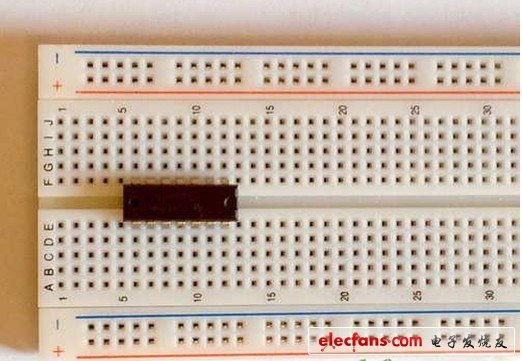 在面包板的中間插入TLC3704集成電路（IC）芯片。